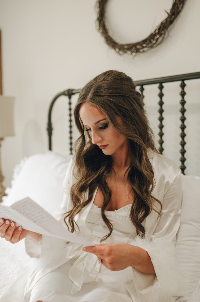 Bride reading letter from the groom privately on wedding morning 