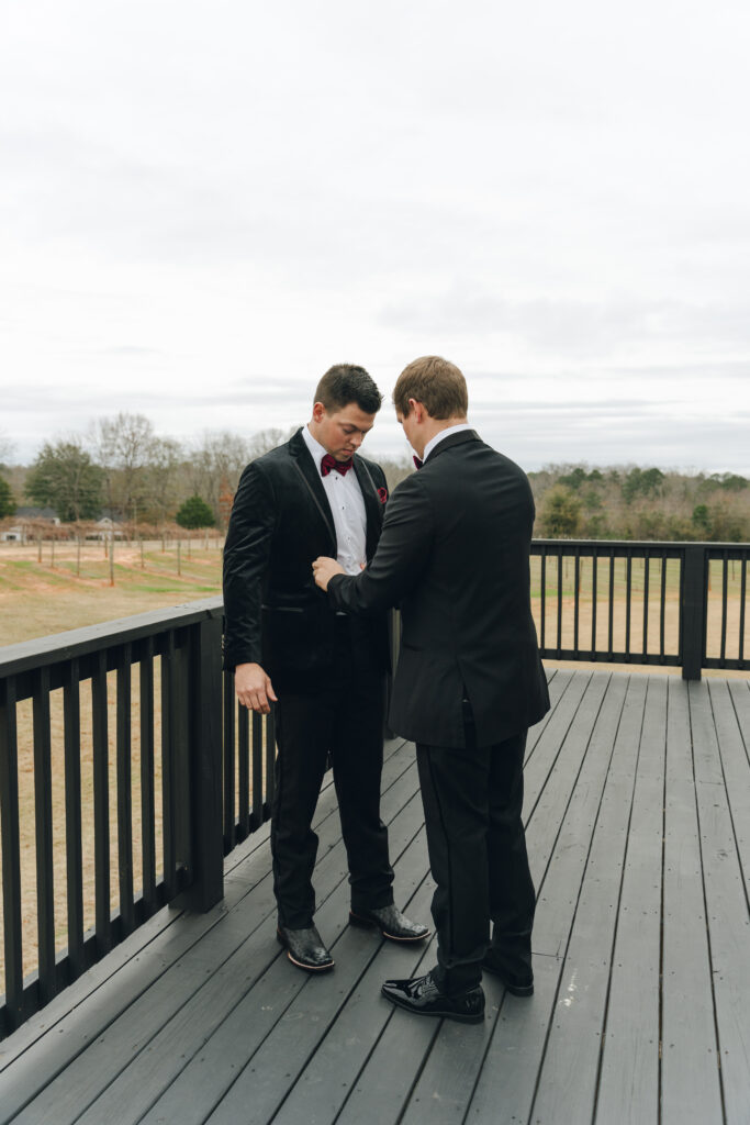 Best man helping groom get ready to walk down the aisle