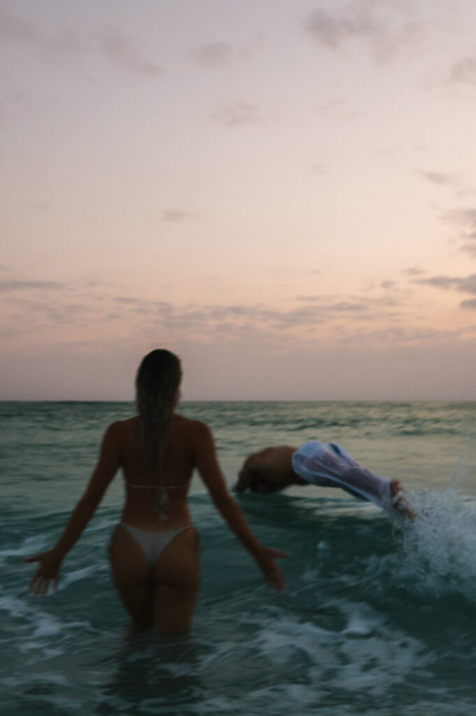 Couple swimming in the ocean during an engagement session on Waikiki beach