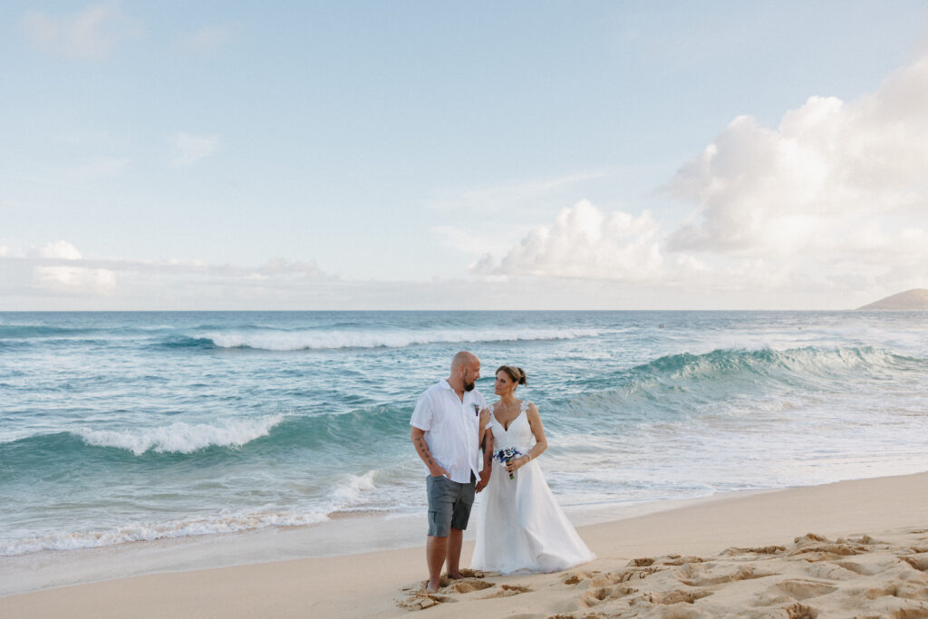 A newlywed couple standing on the beach after ceremony 
