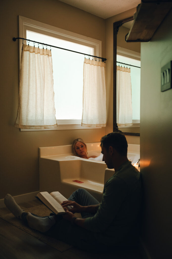 couple taking a bath and groom reading to her while spending the morning together before their elopement